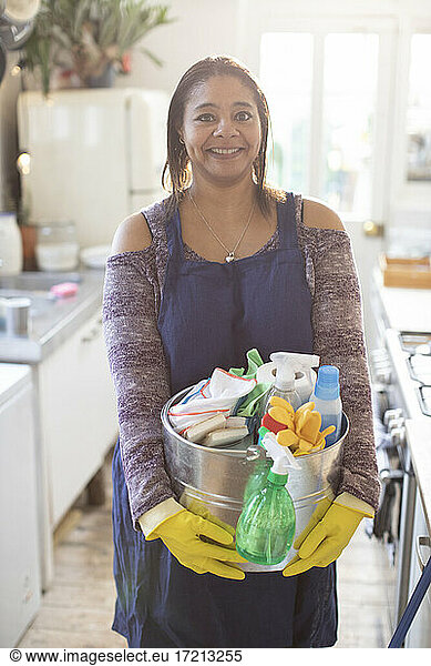 Portrait confident woman with bucket of cleaning supplies