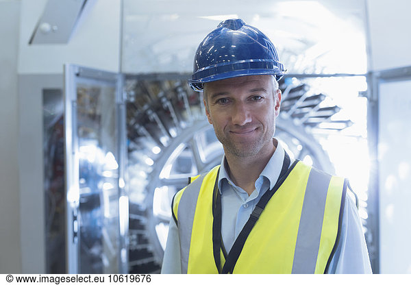 Portrait confident worker in reflective clothing and hard-hat in factory
