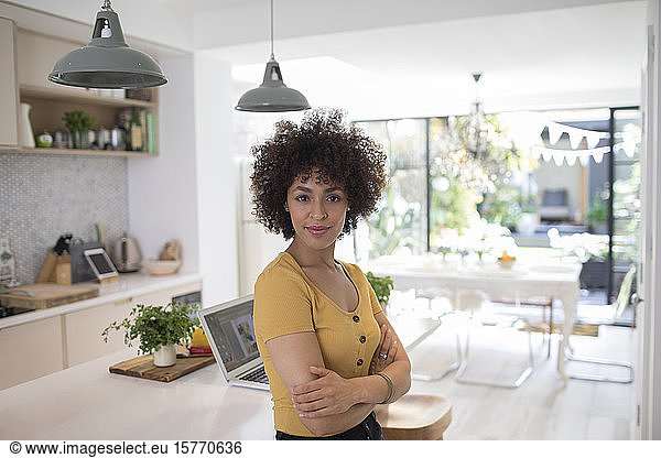 Portrait confident young female freelancer in kitchen