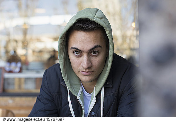 Portrait confident young man in hoody