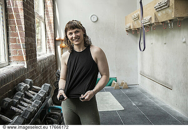 Portrait confident young woman exercising in gym