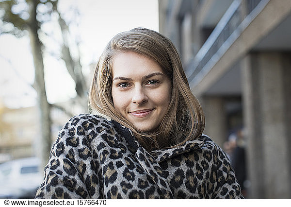 Portrait confident young woman in leopard print coat