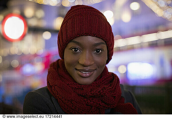 Portrait confident young woman in red knit hat and scarf