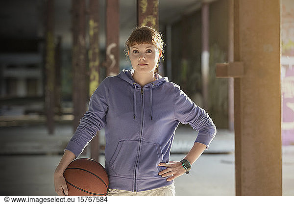 Portrait confident young woman with basketball