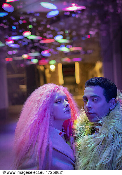 Portrait cool fashionable couple under neon lights