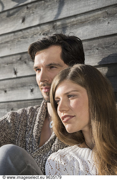 Portrait couple close up relaxing wooden wall