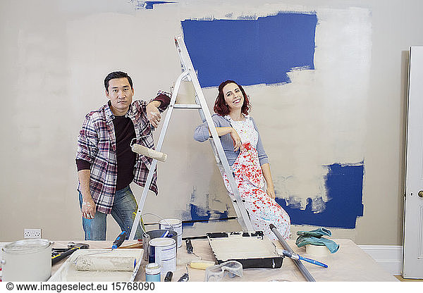 Portrait couple redecorating  painting wall