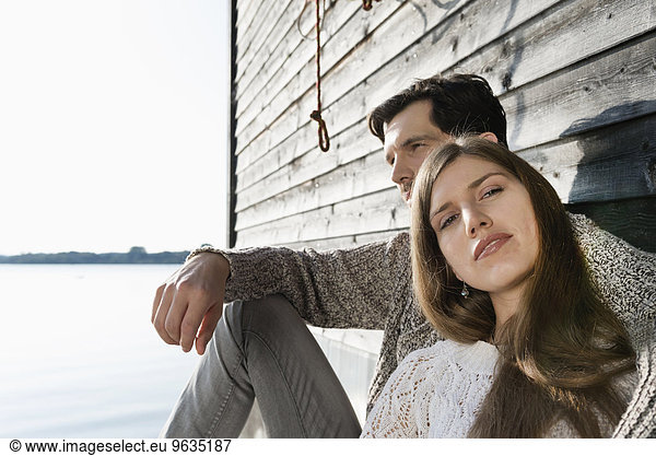 Portrait couple relaxing wooden wall sunset