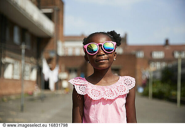 Portrait cute girl in bright pink sunglasses