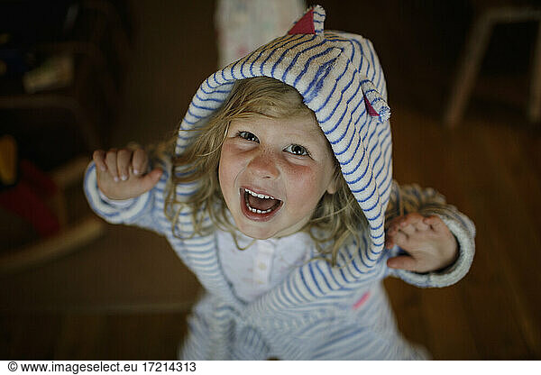 Portrait cute girl in striped hooded bathrobe