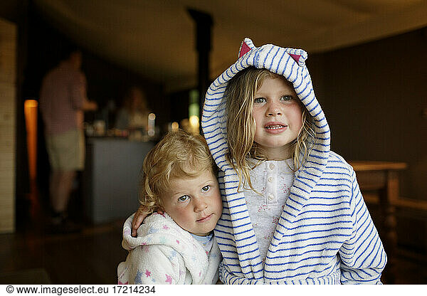 Portrait cute sisters in bathrobes