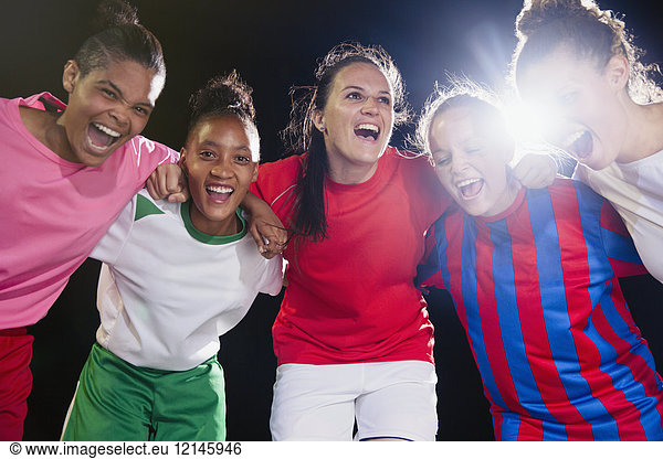 Portrait enthusiastic  confident young female soccer team bonding and cheering in huddle