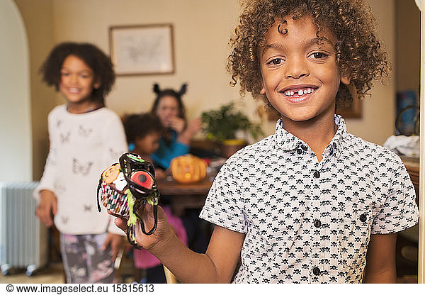 Portrait excited boy holding decorated Halloween cupcake