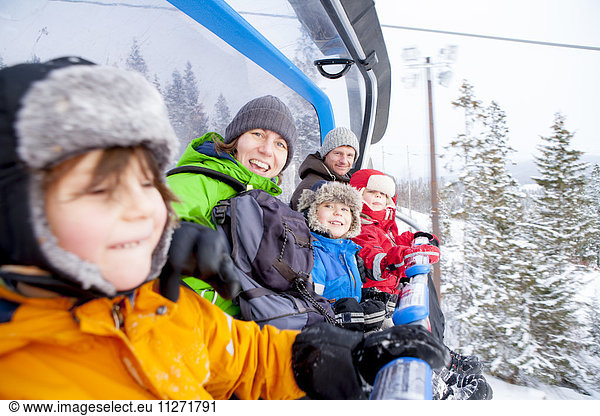 Portrait family riding ski lift