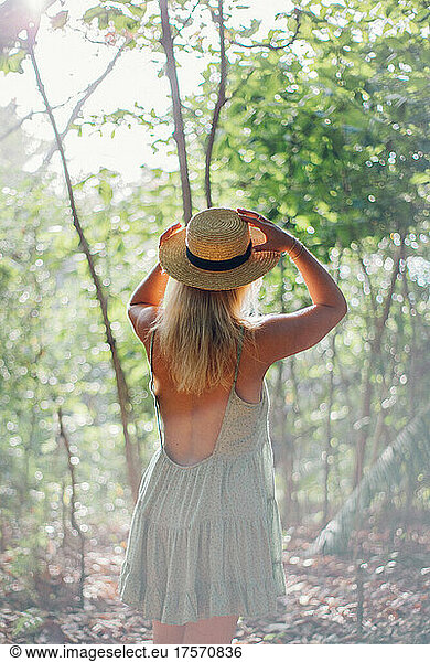 portrait from behind of a blond girl wearing a hat