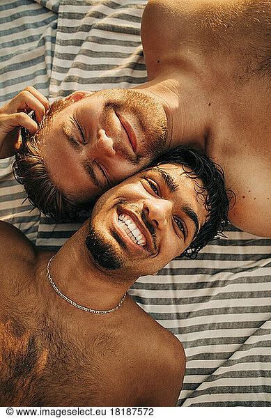 Portrait happy male friends lying down together