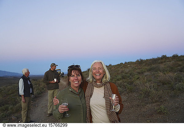 Portrait happy mature women friends on safari drinking champagne