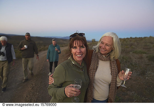 Portrait happy mature women on safari drinking champagne