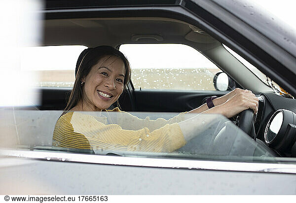 Portrait happy woman driving car