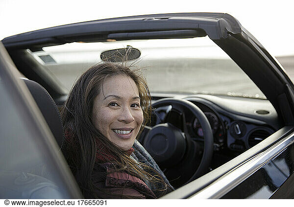 Portrait happy woman in convertible