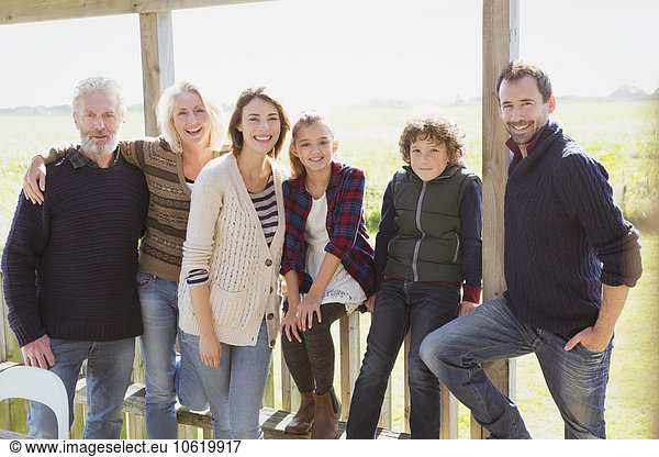 Portrait lächelnde Mehrgenerationen-Familie auf sonniger Veranda