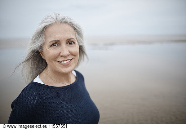Portrait lächelnde Seniorin am Strand