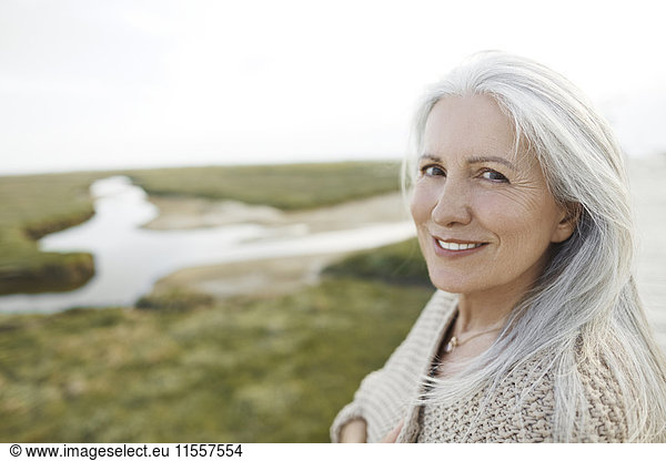 Portrait lächelnde Seniorin am Strand