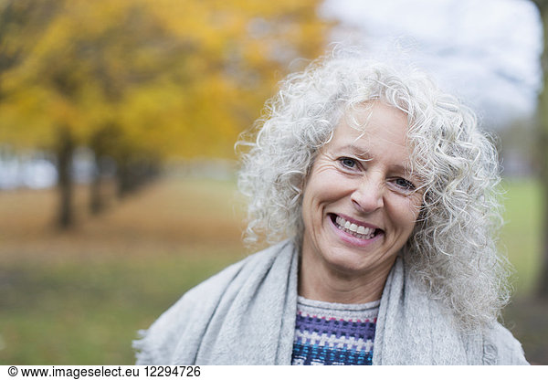 Portrait lächelnde Seniorin im Herbstpark