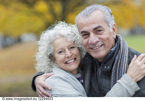 Portrait lächelndes  selbstbewusstes Seniorenpaar umarmend