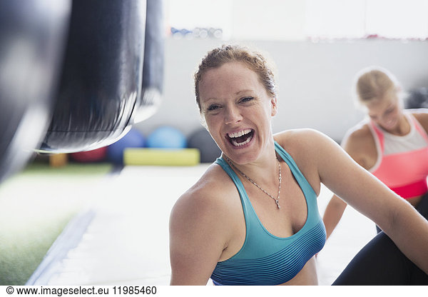 Portrait laughing female boxer stretching in gym