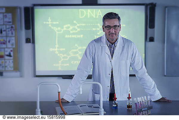 Portrait male science teacher teaching DNA lesson at projection screen