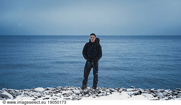 Portrait of a backpacker in front of a large body of water