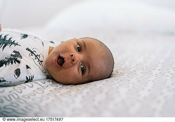 Portrait of a bald baby lying on the bed