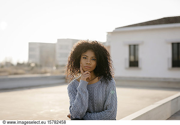Portrait of a beautiful young woman on a rooftop at sunset