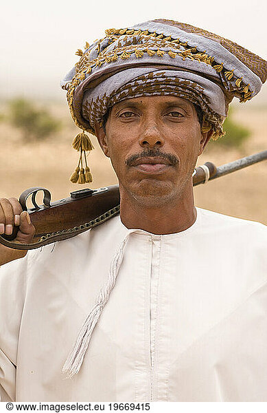 Portrait of a bedouin man with his rifle  Jabal Samhan  Oman.