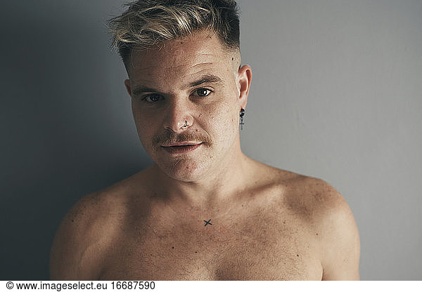 Portrait of a blond boy with a moustache and piercing