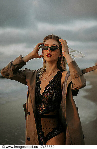 Portrait of a blonde girl in sunglasses and trench coats.