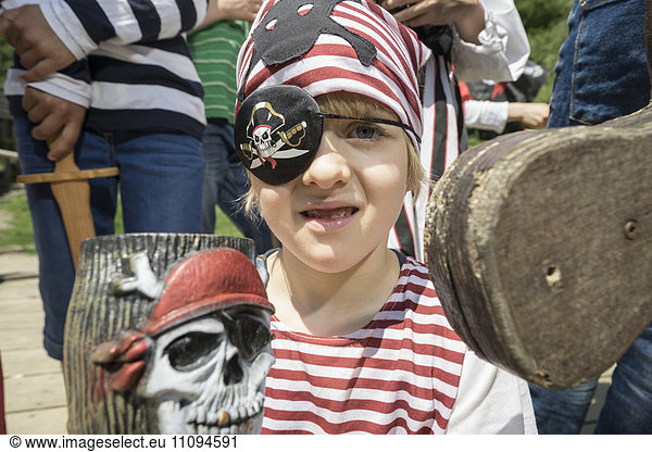 Portrait of a boy dressed up as a pirate on a pirate ship with his friends standing behind him  Bavaria  Germany