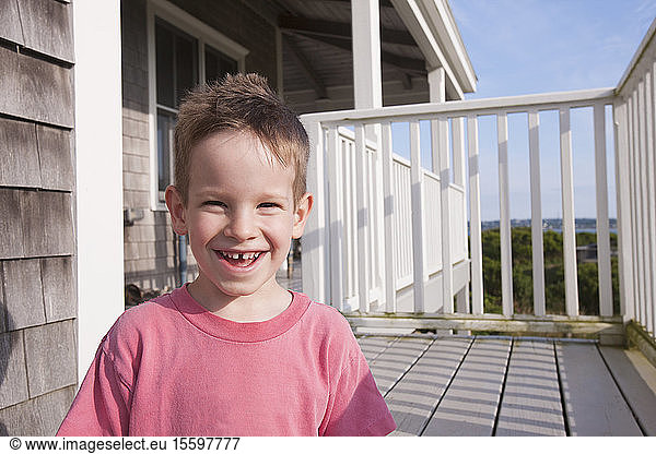 Portrait of a boy smiling on a porch