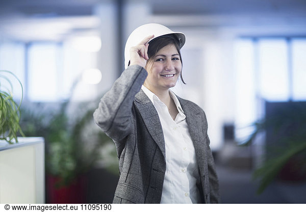 Portrait of a businesswoman smiling in an office and wearing hardhat  Freiburg Im Breisgau  Baden-Württemberg  Germany