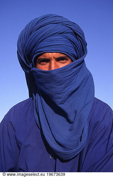 Portrait of a camel rider standing in the desert  Tunisia  North Africa.