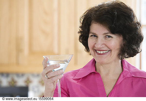 Portrait of a cheerful woman holding a martini glass.