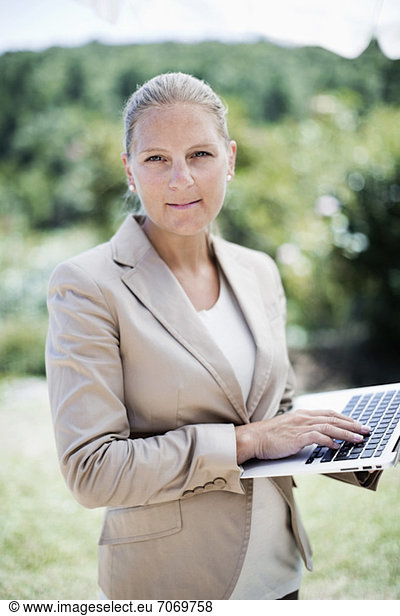 Portrait of a confident businesswoman using laptop