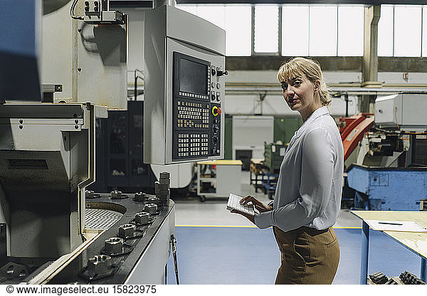 Portrait of a confident businesswoman using wireless keyboard in a factory