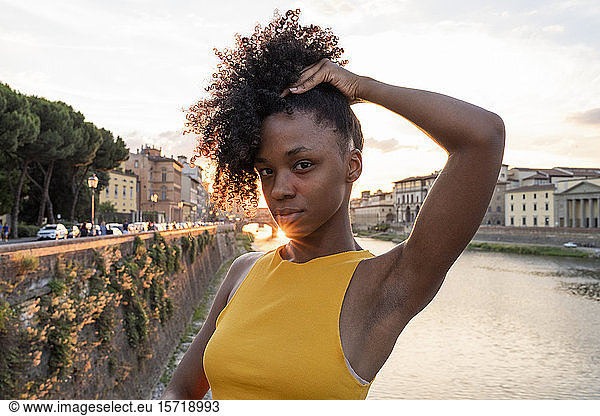 Portrait of a confident young woman at river Arno at sunset  Florence  Italy