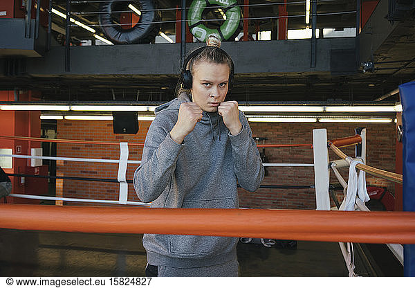 Portrait of a female boxer with headphones in ring