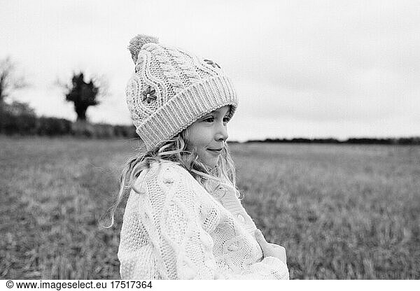 portrait of a girl cosy in a cardigan whilst playing outside