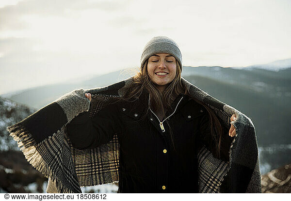 Portrait of a girl in a hat with the snowy mountains in the background