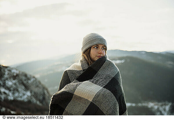 Portrait of a girl in a hat with the snowy mountains in the background