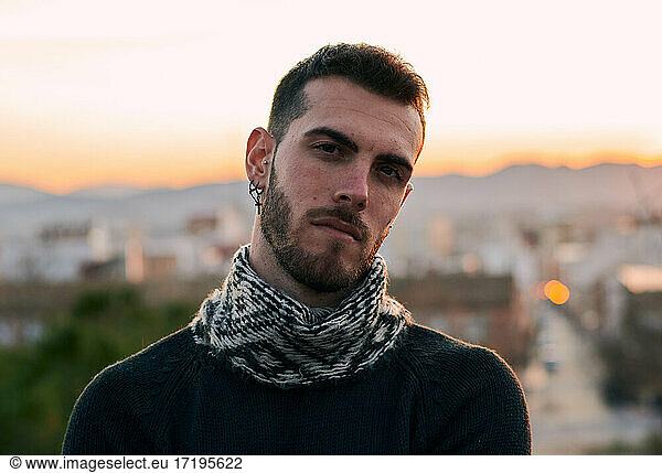 Portrait of a handsome man looking at the camera at sunset